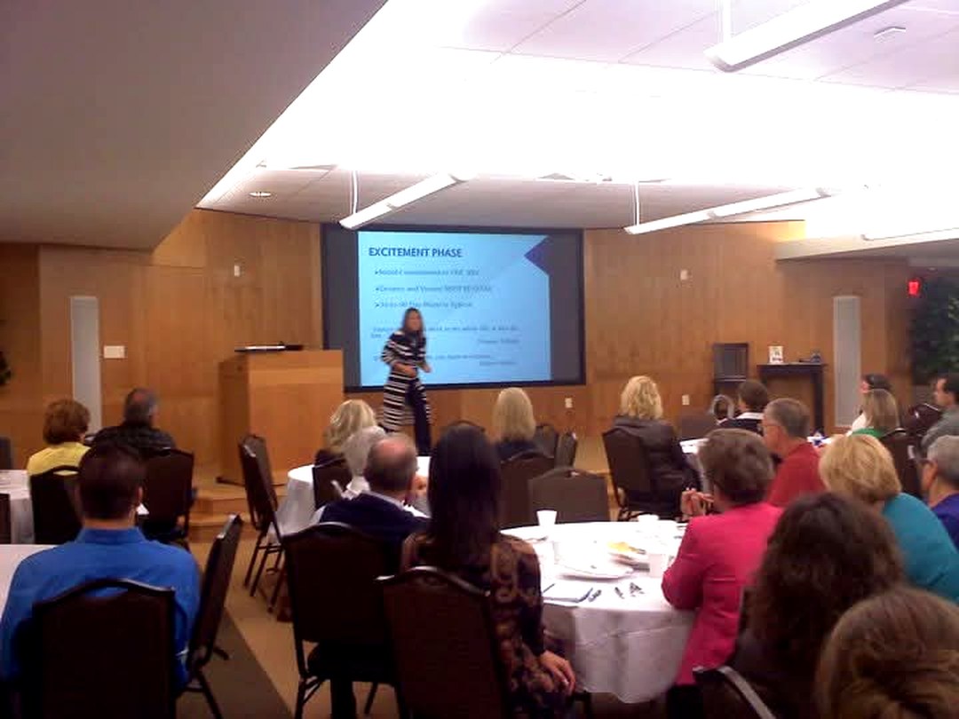 Elizabeth Ward delivering a keynote to a full conference room